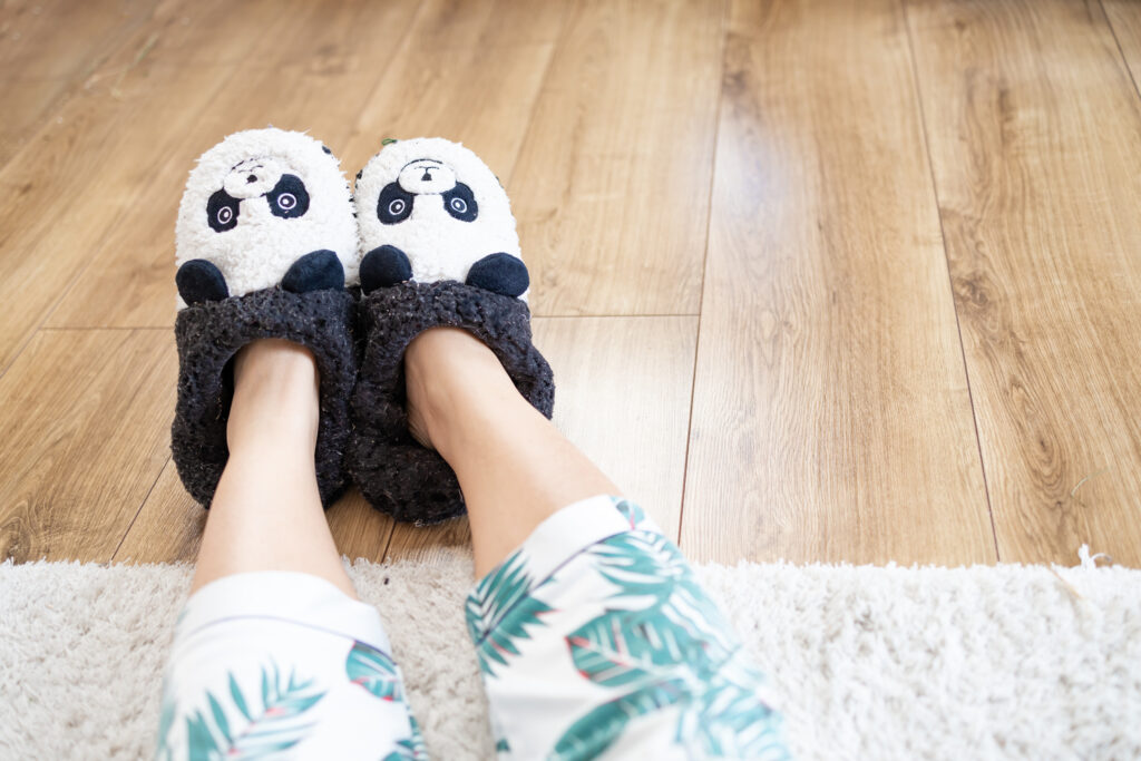 young woman in soft funny slippers at home on wood 2025 03 13 01 07 14 utc